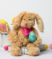 bunny sitting on a white background and decorative colorful easter eggs