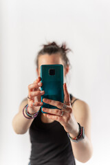 Woman with bracelets and rings taking a vertical picture with her mobile phone. Foreground.