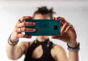Woman with bracelets and rings taking a horizontal picture with her mobile phone. Foreground.