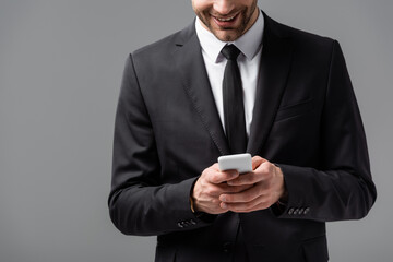 partial view of corporative manager messaging on cellphone isolated on grey