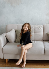 Obraz premium girl in a black swimsuit sitting on the couch