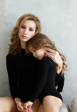 portrait of mother with daughter in black bodysuits
