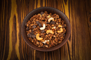 Chocolate granola cereal with nuts in a bowl.