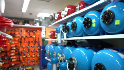 Shelf with hydroaccumulators in the store. Blue color, battery water tank. Automatic water supply station. Application for a private house. blurry