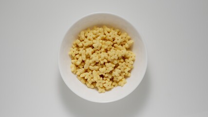 Breakfast kid corn flakes in white dish, Top view