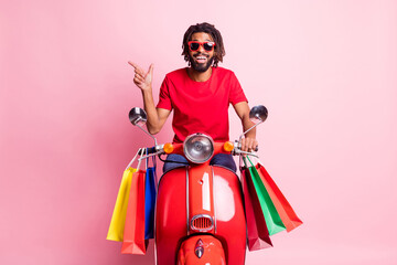 Photo of young black man happy indicate finger empty space select suggest ride bike shopping bag isolated over pastel color background