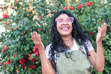 A young woman wearing sunglasses outdoors in a park.