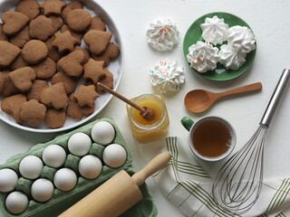 Easter festive background with eggs, cookies, marshmallows, tea with honey.