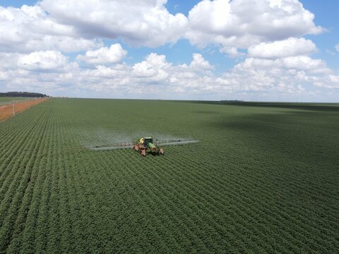 Imagem a&eacute;rea de ambiente agr&iacute;cola durante pulveriza&ccedil;&atilde;o da lavoura.