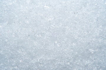 Background with close-up of snow under strong magnification. Slightly melted snow with sharp edges in soft focus.