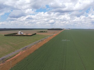 Imagem aérea de ambiente agrícola durante pulverização da lavoura.