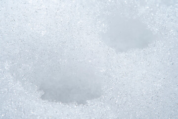 Background with close-up of snow under strong magnification. Slightly melted snow with sharp edges in soft focus.