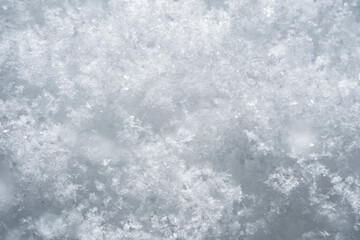 Background with close-up of snow under strong magnification. Slightly melted snow with sharp edges in soft focus.