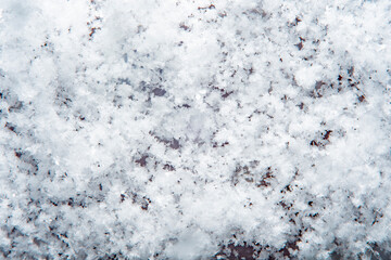 Background with close-up of snow under strong magnification. Slightly melted snow with sharp edges in soft focus.