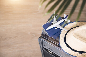 Obraz premium Lifestyle and traveling concept after quarantine Passports, hat and model airplane on gray suitcase