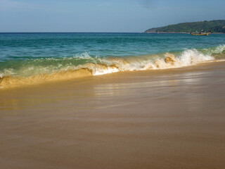 Sea surf on a sandy beach on a summer sunny day.