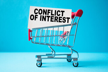 a business card with text CONFLICT OF INTEREST in a shopping cart. business and finance
