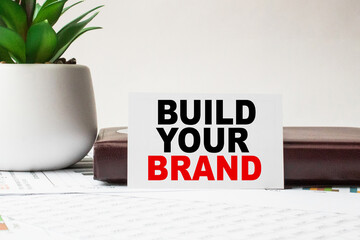 Notepad with inscriptions BUILD YOUR BRAND on a white background. business concept.