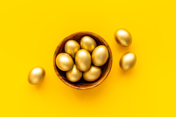 Golden eggs in wooden bowl. Wealth and good luck concept. Easter decoration