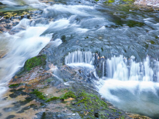 Fototapeta premium Aguas sedosas en un torrente de montaña gracias a la técnica de larga exposición en el Parque Nacional de Ordesa, Pirineos españoles
