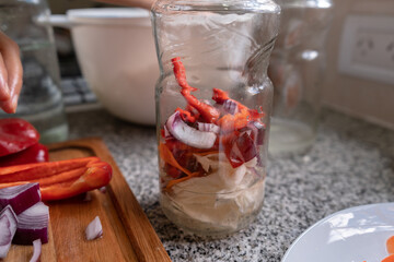 Preparing red onion, cabbage, and bell bell pepper pickles.