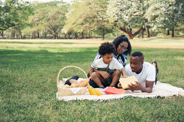 Happy picnic relax black people family and son in garden with bread in basket