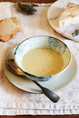 Cheese cream soup in bowl on beige linen table. Selective focus