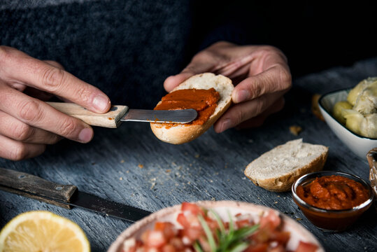 man spreads vegan sobrasada on a piece of bread