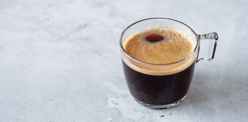 Fresh hot espresso in a transparent glass cup. Black coffee on stone background - Image