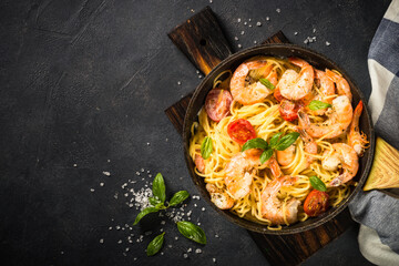 Pasta seafood with shrimp on black table.