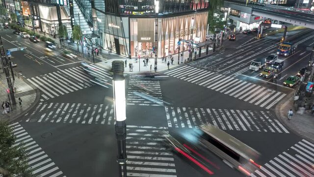 Busy Traffic Intersection In Front Of Tokyo Ginza Shopping Plaza In The Evening - timelapse shot