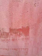 old pink shabby metal wall painted unevenly in several layers