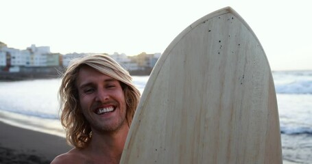 Close up of young surfer man smiling in camera