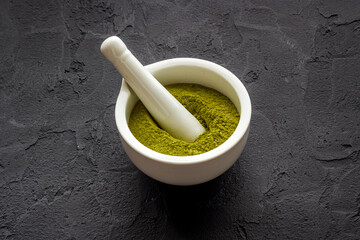 Henna powder in white mortar. Herbal natural hair dye