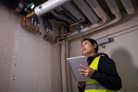 Female plumber checking pipes