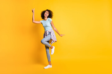 Fototapeta na wymiar Full length photo of sweet dark skin curly woman dressed blue t-shirt showing v-sign empty space isolated yellow color background