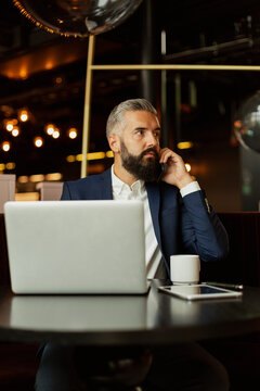 Businessman talking via cell phone in cafe