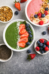 Matcha green tea breakfast superfoods smoothies bowl topped with strawberries, blueberries, coconut flakes Overhead, top view, flat lay