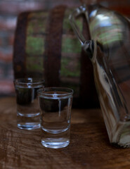 Hard alcoholic drink or brandy from fermented fruits, old wooden table, still life