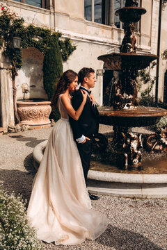Walk of the newlyweds at the fountain against the backdrop of the old mansion. Summer sunny day.