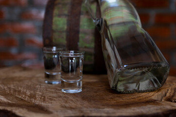 Hard alcoholic drink or brandy from fermented fruits, old wooden table, still life