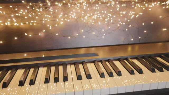 Beautiful synth with Christmas decorations. Close-up synthesizer keys. Synthesizer with New Year's lights.