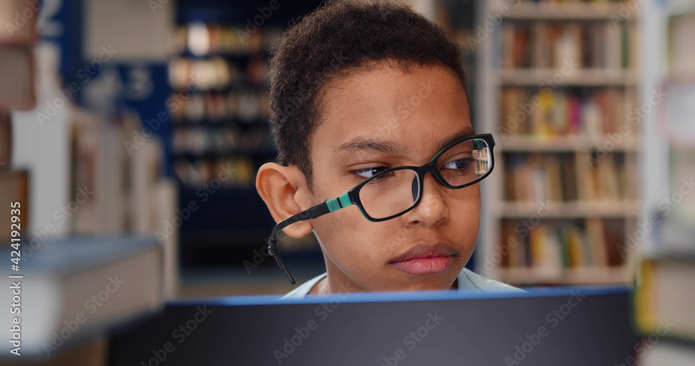 Poster Tired african american student boy stuck with laptop and books at library