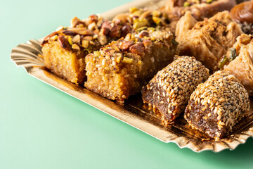 Assortment of Ramadan dessert baklava on green background