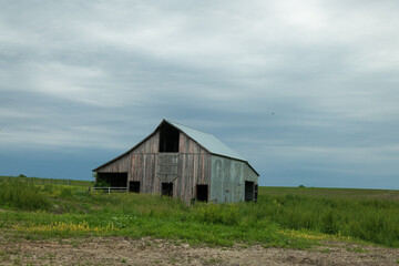 Fototapeta na wymiar Missouri farm barn in the field under overcast sky