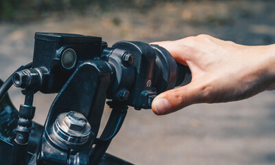 Close up of motorcycle rider hand pressing the button for start motorcycle engine.