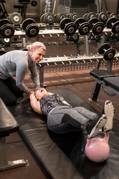 Woman training in gym with personal trainer