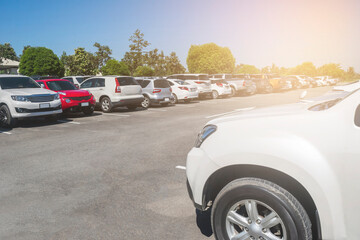 Car parked in large asphalt parking lot with white cloud and blue sky background. Outdoor parking lot  in a park © merrymuuu