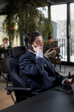 Businessman in cafe talking via cell phone