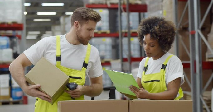 Diverse colleagues doing inventory in warehouse scanning barcode